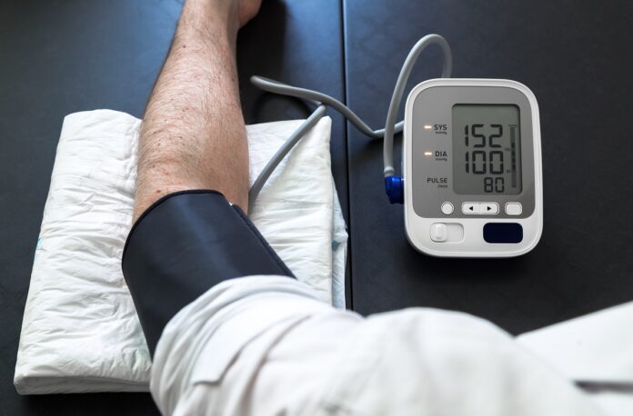 Hypertensive patient performing a blood pressure auto test / man self-monitoring of blood pressure with a tensiometer